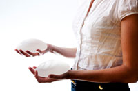 woman holding breast implants